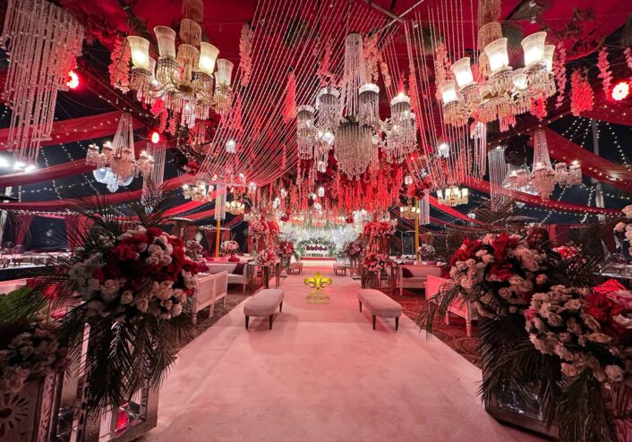 indoor baraat setup, royal red theme, carpeted walkway, floral decor