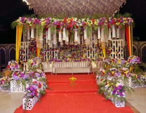 mehndi-stage indoor stage, floral decor, colorful backdrop, wedding designers